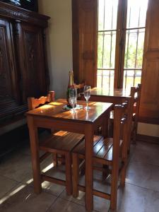 a wooden table with two glasses of wine on it at El Colonial in Colón