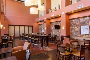 a restaurant with tables and chairs and a fireplace at Hampton Inn & Suites Mission in Mission