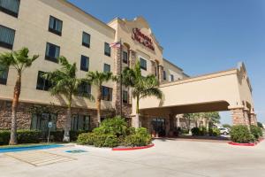 a hotel with palm trees in front of it at Hampton Inn & Suites Mission in Mission