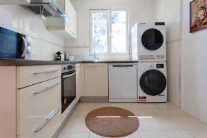 cocina con lavadora, lavadora y secadora en Maison proche Paris vue la Tour Eiffel, en Arcueil