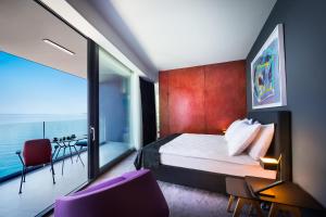 a hotel room with a bed and a balcony at Boutique & Design Hotel Navis - Small Luxury Hotels of the World in Opatija