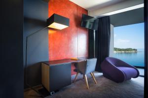 a room with a desk and a purple chair at Boutique & Design Hotel Navis - Small Luxury Hotels of the World in Opatija