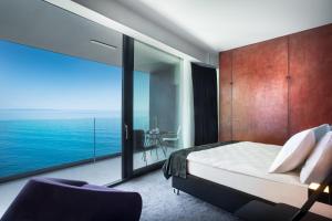 a bedroom with a bed and a large window at Boutique & Design Hotel Navis - Small Luxury Hotels of the World in Opatija