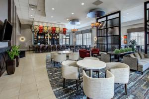 a lobby of a hotel with tables and chairs at Embassy Suites Columbus - Airport in Columbus