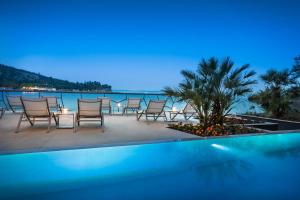 a group of chairs and a table next to a swimming pool at Boutique & Design Hotel Navis - Small Luxury Hotels of the World in Opatija