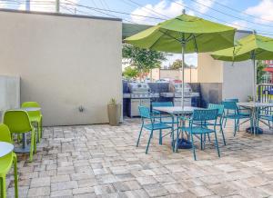 d'une terrasse avec des tables, des chaises et un parasol. dans l'établissement Home2 Suites by Hilton Mobile West I-10 Tillmans Corner, à Tillmans Corner