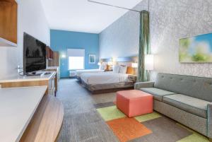 um quarto de hotel com uma cama e um sofá em Home2 Suites by Hilton Mobile West I-10 Tillmans Corner em Tillmans Corner