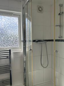 uma casa de banho com um chuveiro e uma janela em no.6 overnight stays em Hindlip