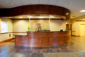 a woman sitting at a bar in a lobby at DoubleTree by Hilton Midland Plaza in Midland