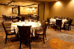 a dining room with tables and chairs with white table cloth at Wyndham Midland Downtown in Midland