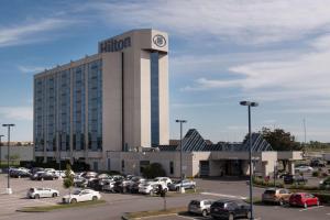 a hotel with cars parked in a parking lot at Hilton Montreal/Laval in Laval