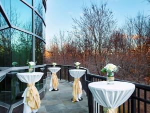 Un balcón con dos mesas con flores. en Hilton Garden Inn Rockville - Gaithersburg, en Rockville