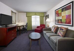a living room with a couch and a tv at Hilton Garden Inn Rockville - Gaithersburg in Rockville