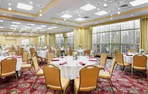 een conferentiezaal met tafels, stoelen en ramen bij Hilton Garden Inn Rockville - Gaithersburg in Rockville