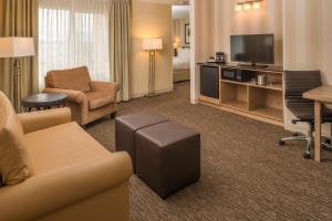 a living room with a couch and a tv in a hotel room at DoubleTree by Hilton Portland - Beaverton in Beaverton