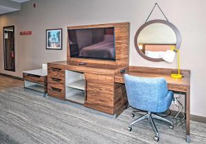 a desk with a television and a blue chair at Hampton by Hilton Ottawa in Ottawa