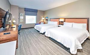 a hotel room with two beds and a flat screen tv at Hampton by Hilton Ottawa in Ottawa
