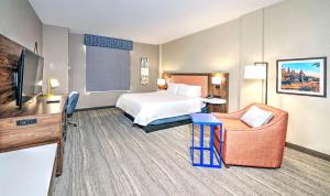 a hotel room with a bed and a chair at Hampton by Hilton Ottawa in Ottawa