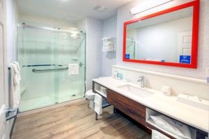 a bathroom with a shower and a sink and a mirror at Hampton by Hilton Ottawa in Ottawa