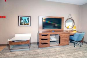 a desk with a television and a chair in a room at Hampton by Hilton Ottawa in Ottawa