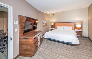 a bedroom with a bed and a flat screen tv at Hampton by Hilton Ottawa in Ottawa