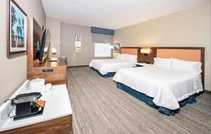 a hotel room with two beds and a flat screen tv at Hampton by Hilton Ottawa in Ottawa