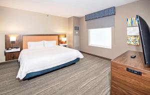 a hotel room with a bed and a flat screen tv at Hampton by Hilton Ottawa in Ottawa