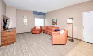 a living room with a couch and a tv at Hampton by Hilton Ottawa in Ottawa
