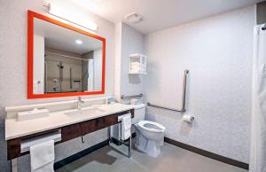 a bathroom with a toilet and a sink and a mirror at Hampton by Hilton Ottawa in Ottawa
