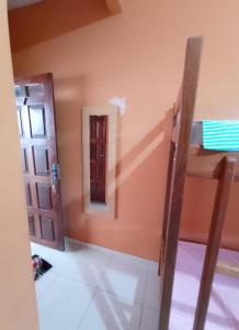 Habitación con cama, espejo y puerta en Caju Hostel en Alter do Chao