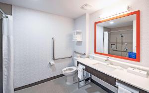 a bathroom with a toilet and a sink and a mirror at Hampton by Hilton Ottawa in Ottawa