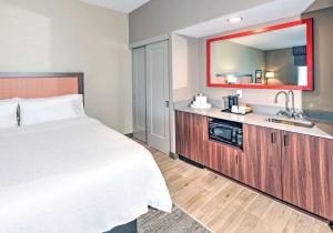 a hotel room with a bed and a sink at Hampton by Hilton Ottawa in Ottawa