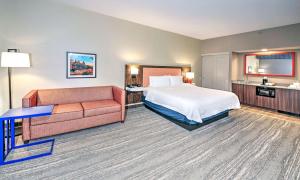 a hotel room with a bed and a couch at Hampton by Hilton Ottawa in Ottawa