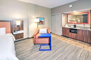 a hotel room with a bed and a chair and a sink at Hampton by Hilton Ottawa in Ottawa