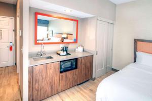 a hotel room with a bed and a sink and a mirror at Hampton by Hilton Ottawa in Ottawa