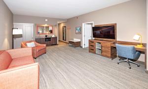 a living room with a couch and a desk and a television at Hampton by Hilton Ottawa in Ottawa