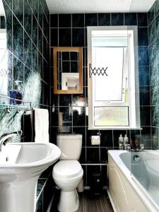 a bathroom with a toilet and a sink and a tub at Cosy bright home in Murrayfield in Edinburgh