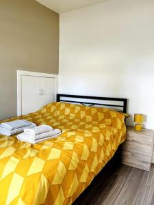 a bedroom with a yellow bed with two pillows on it at Cosy bright home in Murrayfield in Edinburgh