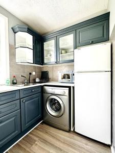 a kitchen with a washing machine and a refrigerator at Cosy bright home in Murrayfield in Edinburgh