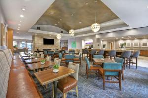 a restaurant with tables and chairs and a couch at Homewood Suites Dallas-Frisco in Frisco