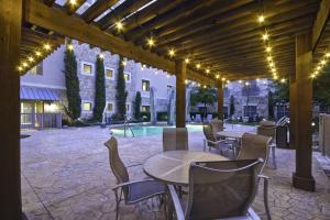 a patio with tables and chairs and a pool at Homewood Suites Dallas-Frisco in Frisco