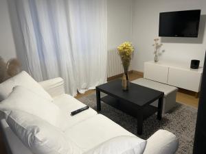 un soggiorno con divano bianco e tavolo di Guibert Home : Studio 4 pers a Villeneuve-le-Roi