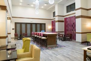 una sala de espera con mesa y sillas en Hampton Inn & Suites Bay City en Bay City