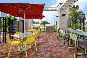 un patio con mesas, sillas y una parrilla en Home2 Suites by Hilton Harvey New Orleans Westbank, en Harvey
