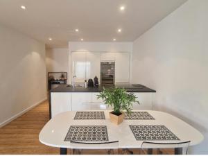 a kitchen with a white table with a potted plant at Centre de Nice - Mar&eacute;chal - Balcon 500m Promenade des Anglais in Nice