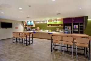 un restaurante con bar con taburetes en Home2 Suites by Hilton Harvey New Orleans Westbank, en Harvey