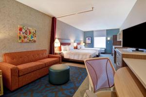 ハーベイにあるHome2 Suites by Hilton Harvey New Orleans Westbankのベッドとソファ付きのホテルルーム