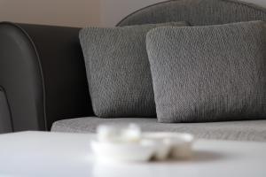 - un canapé gris avec un oreiller sur la table dans l'établissement Delta studio apartman, à Podgorica