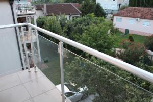 - un balcon avec balustrade blanche sur une maison dans l'établissement Delta studio apartman, à Podgorica