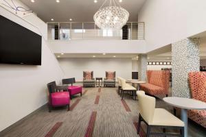 a waiting room with tables and chairs and a chandelier at Homewood Suites Williamsburg in Williamsburg